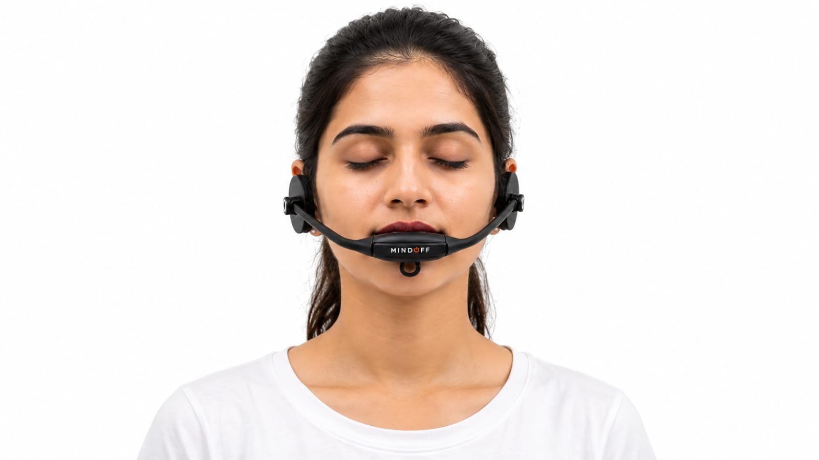 A woman wearing the MindOFF™ device, facing forward with her eyes closed